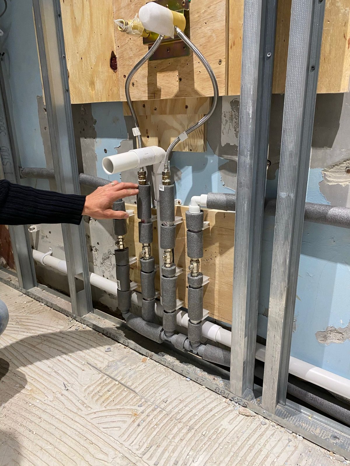 George Ilie installing PEX plumbing manifold during emergency repair Bedford